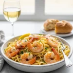 A white bowl filled with shrimp scampi and linguine, garnished with fresh parsley.